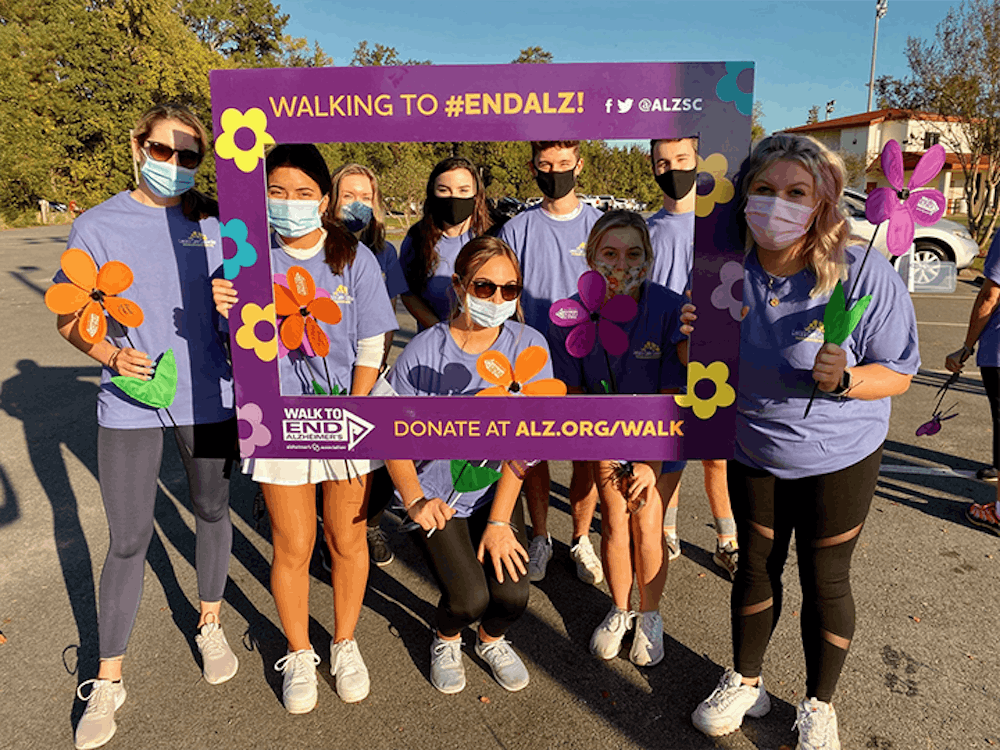 <p>&nbsp;The Advocates Against Alzheimer's group poses with a frame prop during the Alzheimer's Association's "Walk to End Alzheimer's" event on Saturday, Oct. 12.&nbsp;</p>