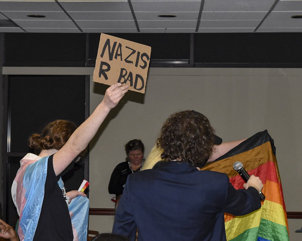<p>Protesters adorned in LGBTQIA+ flags and holding up signs attempt to interrupt Sean Semanko, the founder of Uncensored America, during a Q&amp;A session at Conservative activist Laura Loomer's speech in Russell House on April 18, 2023. Protesters outside the meeting room led chants, while those inside spoke against Loomer's presentation.&nbsp;</p>