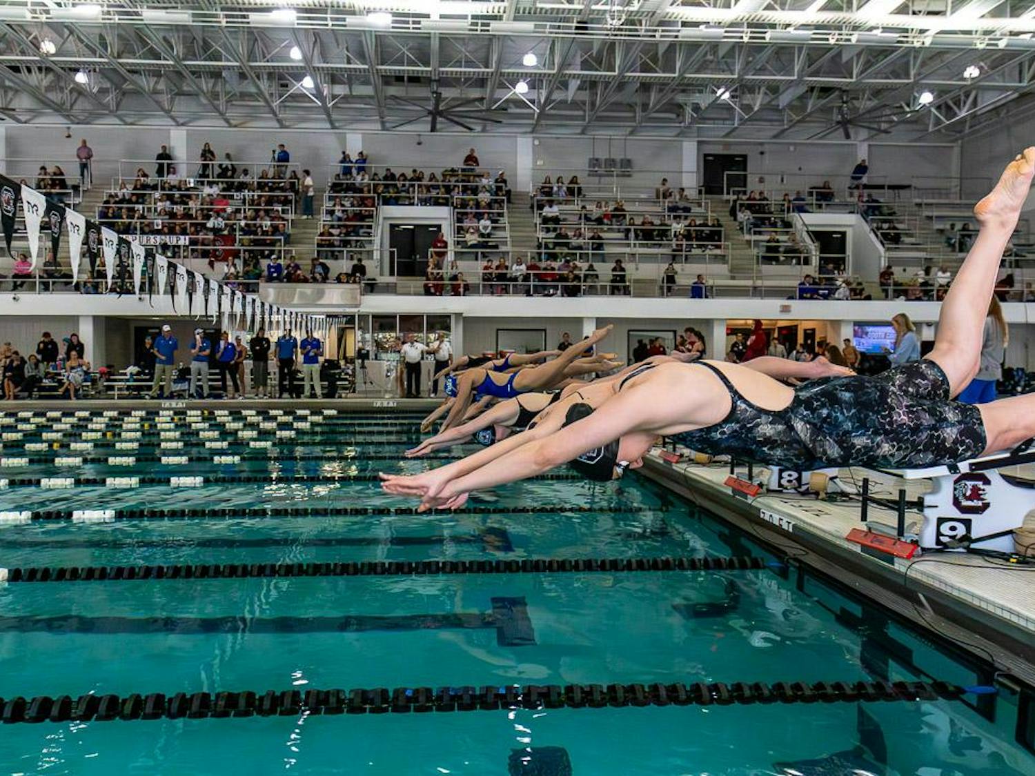 Sophomore freestyle swimmer MaKayla Ciancanelli (right) and other swimmers dive off the block at the start of the second heat of the 500-meter freestyle event at Carolina Natatorium on Jan. 20, 2024. Ciancanelli finished first in the heat with a two-second lead over Duke University junior Yiixuan Chang.