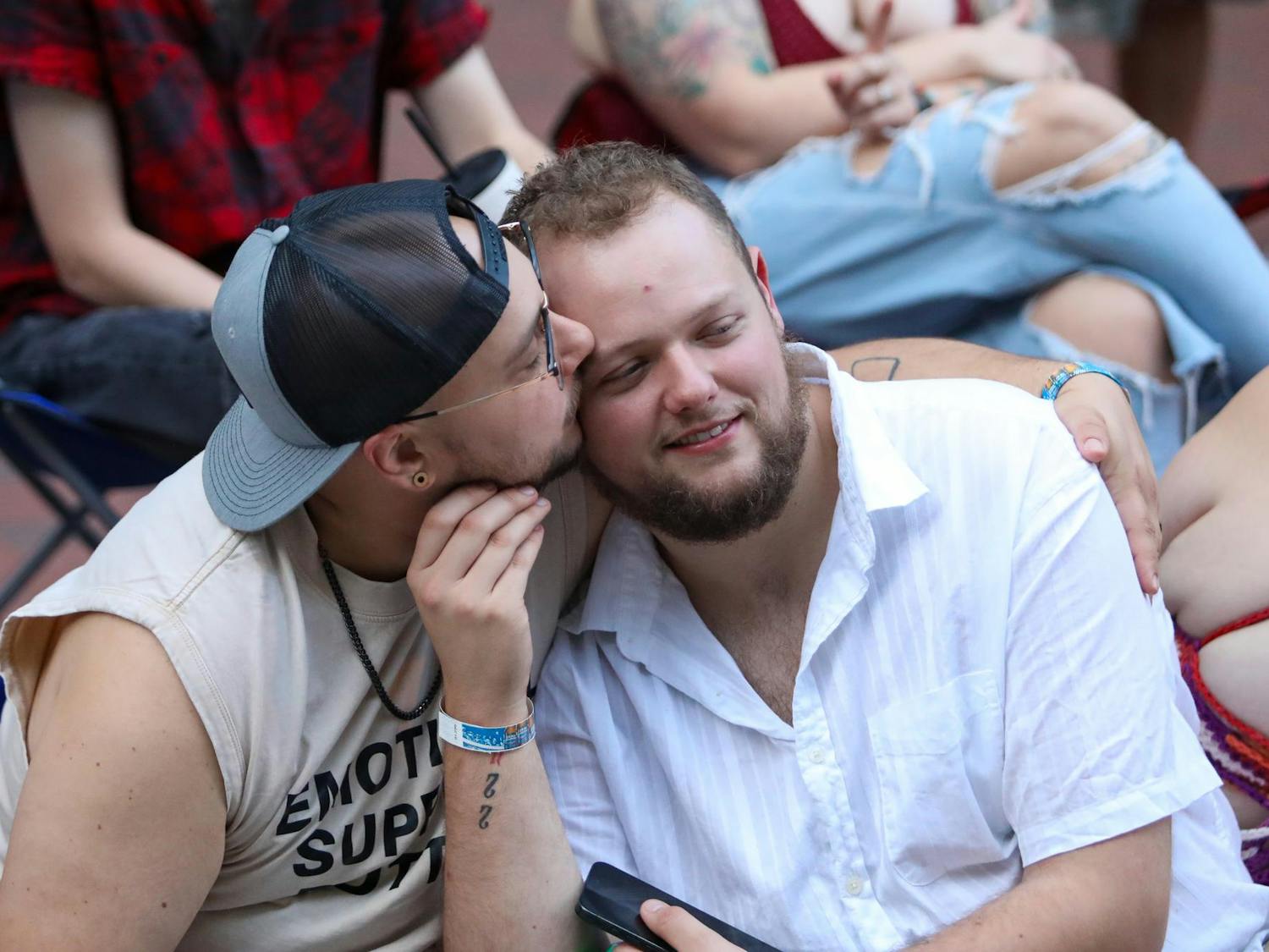 New York residents Cameron Moore and Tyler Stein share a kiss while sitting on the sidewalk before the parade at the Famously Hot SC Pride Festival on Oct. 4, 2025. The two came down to visit friends in Columbia.