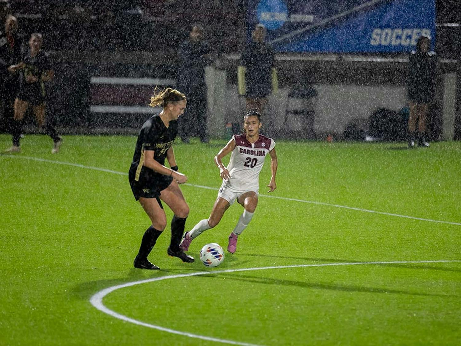 Junior forward Corinna Zullo stays close to a Wake Forest opponent in an attempt to take control of the ball. Even with all the rain, many fans stayed in the crowd to watch the Gamecocks beat Wake Forest at Stone Stadium on Nov. 11, 2022.