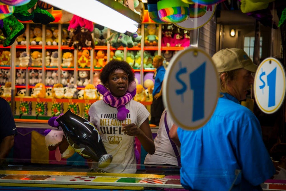 A girl wins a prize after playing a game at the fair.
