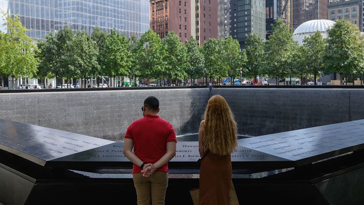 A couple stands before the National September 11 Memorial, marking the site of the south tower at the World Trade Center in New York, on September 8, 2021. (Angela Weiss/AFP via Getty Images/TNS)