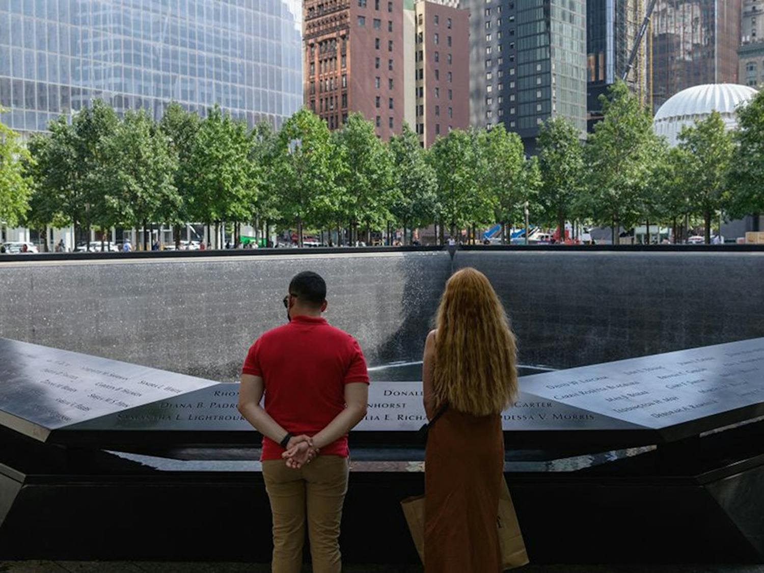 A couple stands before the National September 11 Memorial, marking the site of the south tower at the World Trade Center in New York, on September 8, 2021. (Angela Weiss/AFP via Getty Images/TNS)