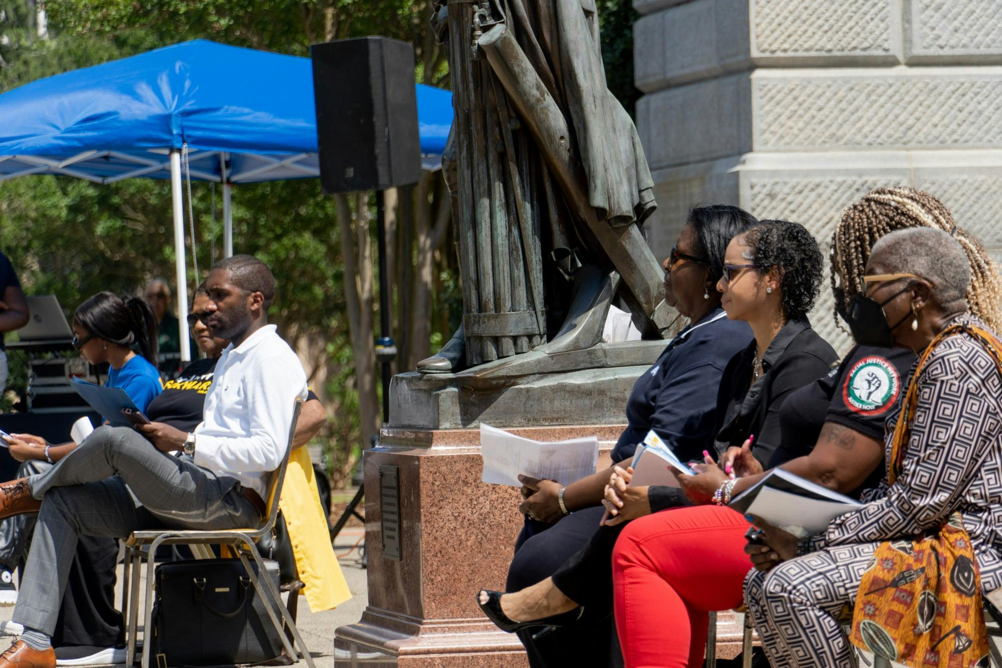 Speaker of the rally held by South Carolina State Conference of the NAACP sit along the SC statehouse on April 23, 2022. Speakers engage in conversation as they prepare to take to the podium to discuss race relations and their issues with the death penalty.