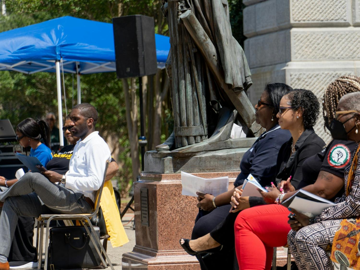 Speaker of the rally held by South Carolina State Conference of the NAACP sit along the SC statehouse on April 23, 2022. Speakers engage in conversation as they prepare to take to the podium to discuss race relations and their issues with the death penalty.