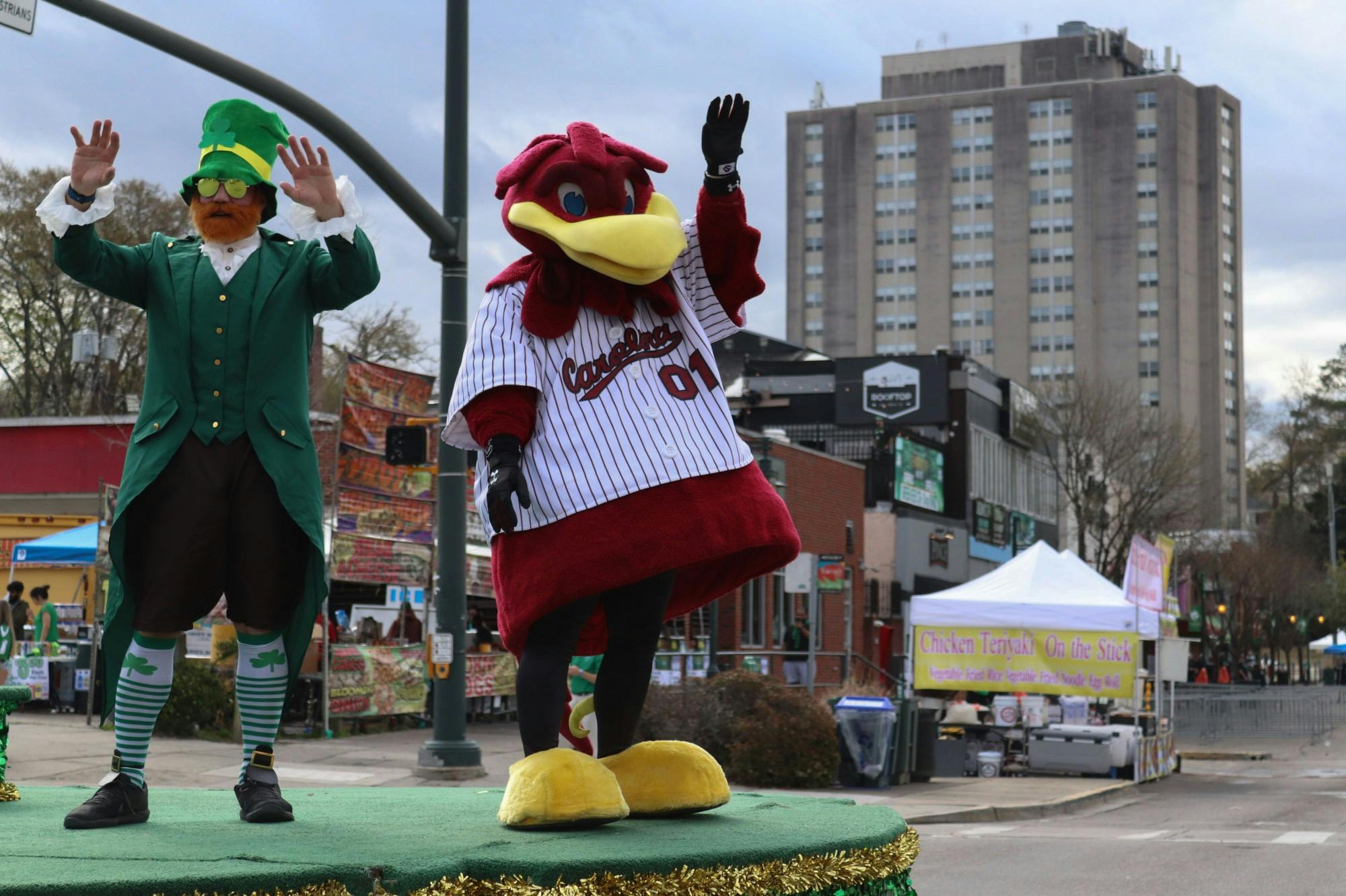 Cocky and a man dressed as a leprechaun wave to the crowd from the grand marshal float in the 40th Annual St. Pats in 5 Points Parade on March 19, 2022