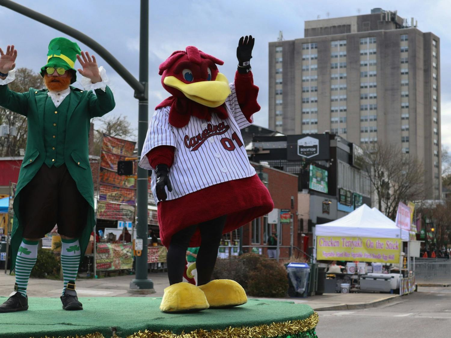 Cocky and a man dressed as a leprechaun wave to the crowd from the grand marshal float in the 40th Annual St. Pats in 5 Points Parade on March 19, 2022