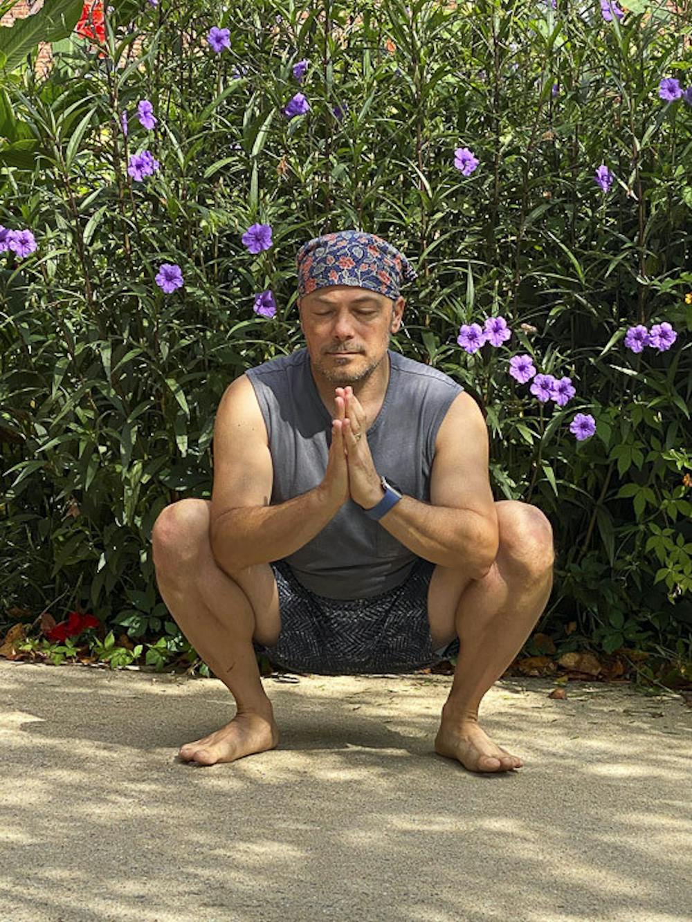 <p>David Moscowitz, a professor at the School of Journalism and Mass Communications sits in the Malasana pose, a.k.a. the Garland pose on Sept. 5, 2020. Moscowitz offers donation funded yoga lessons at Rooted Yoga, on Sunday afternoons.&nbsp;</p>