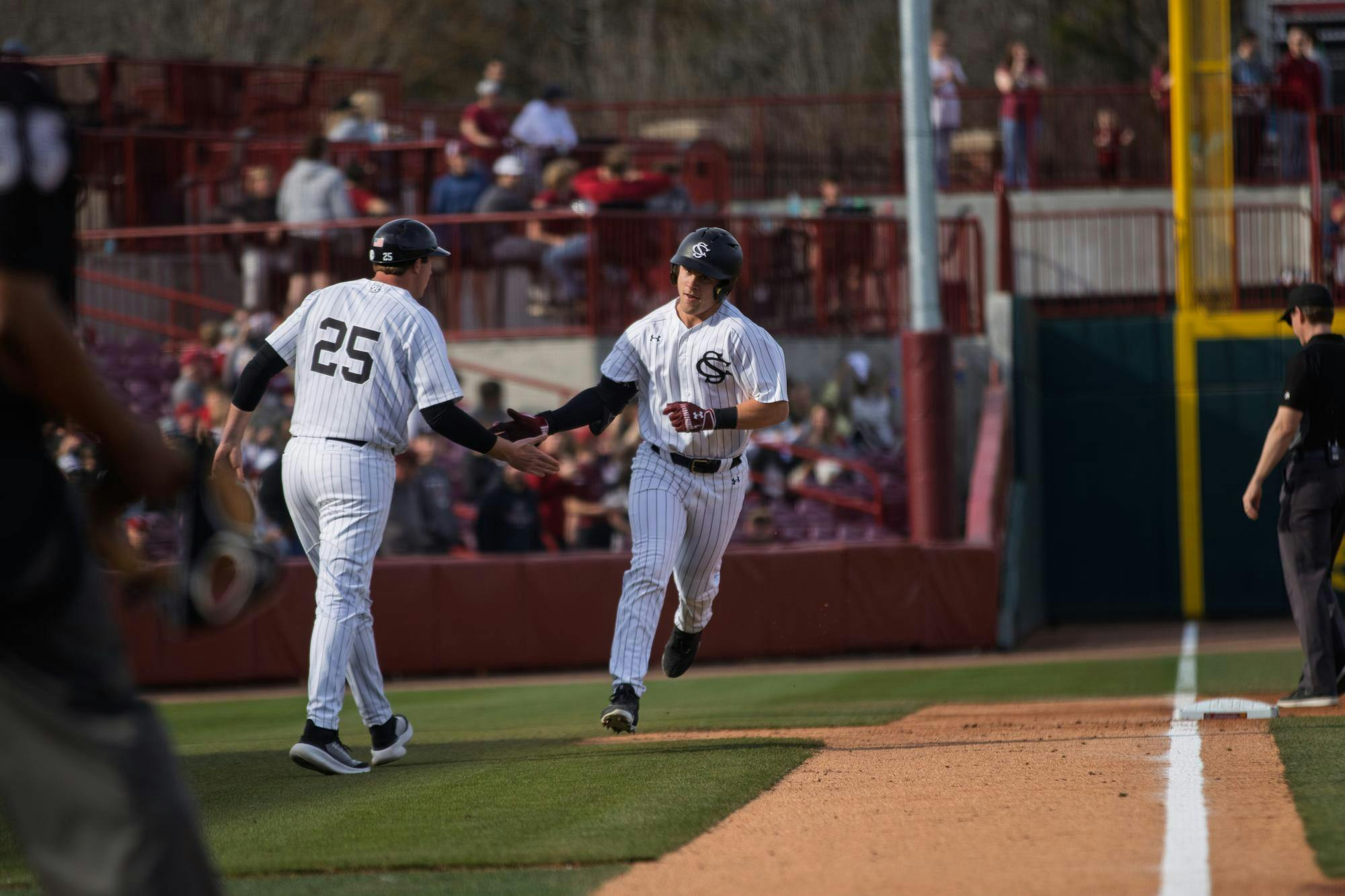Junior catcher Reese Moore celebrating with his third base coach after hitting a home run during a game against Northern Kentucky on Feb. 14, 2026, at Founders Park. Moore had three hits during the game.