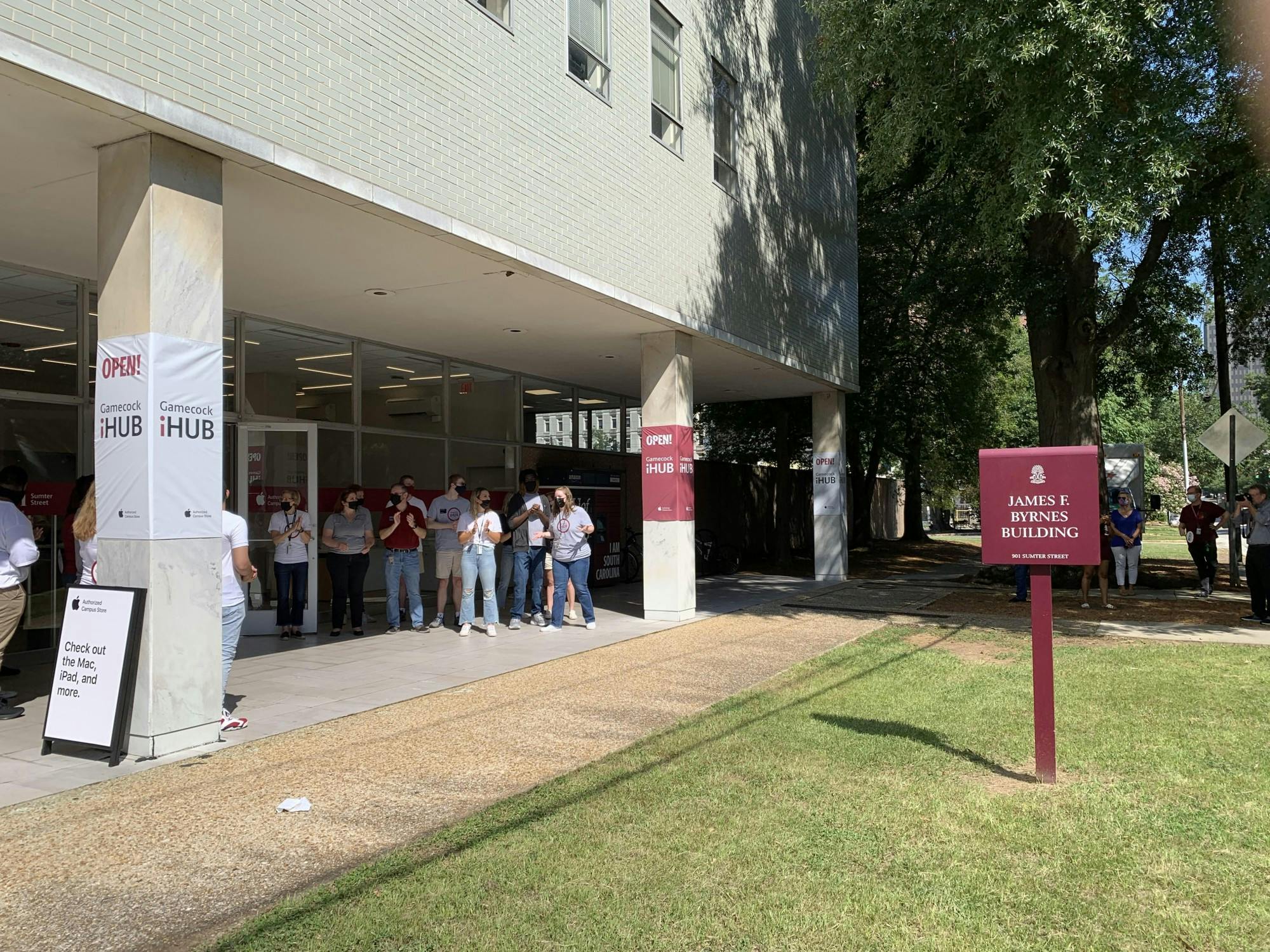 Students working at the new iHub clap as people enter the store. The store opened Aug. 13, 2021, and will service and provide Apple products to the USC community.