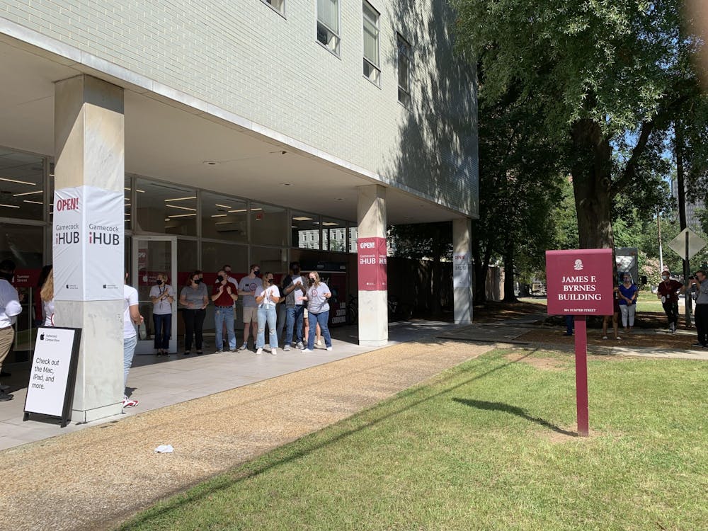 <p>Students working at the new iHub clap as people enter the store. The store opened Aug. 13, 2021, and will service and provide Apple products to the USC community.</p>