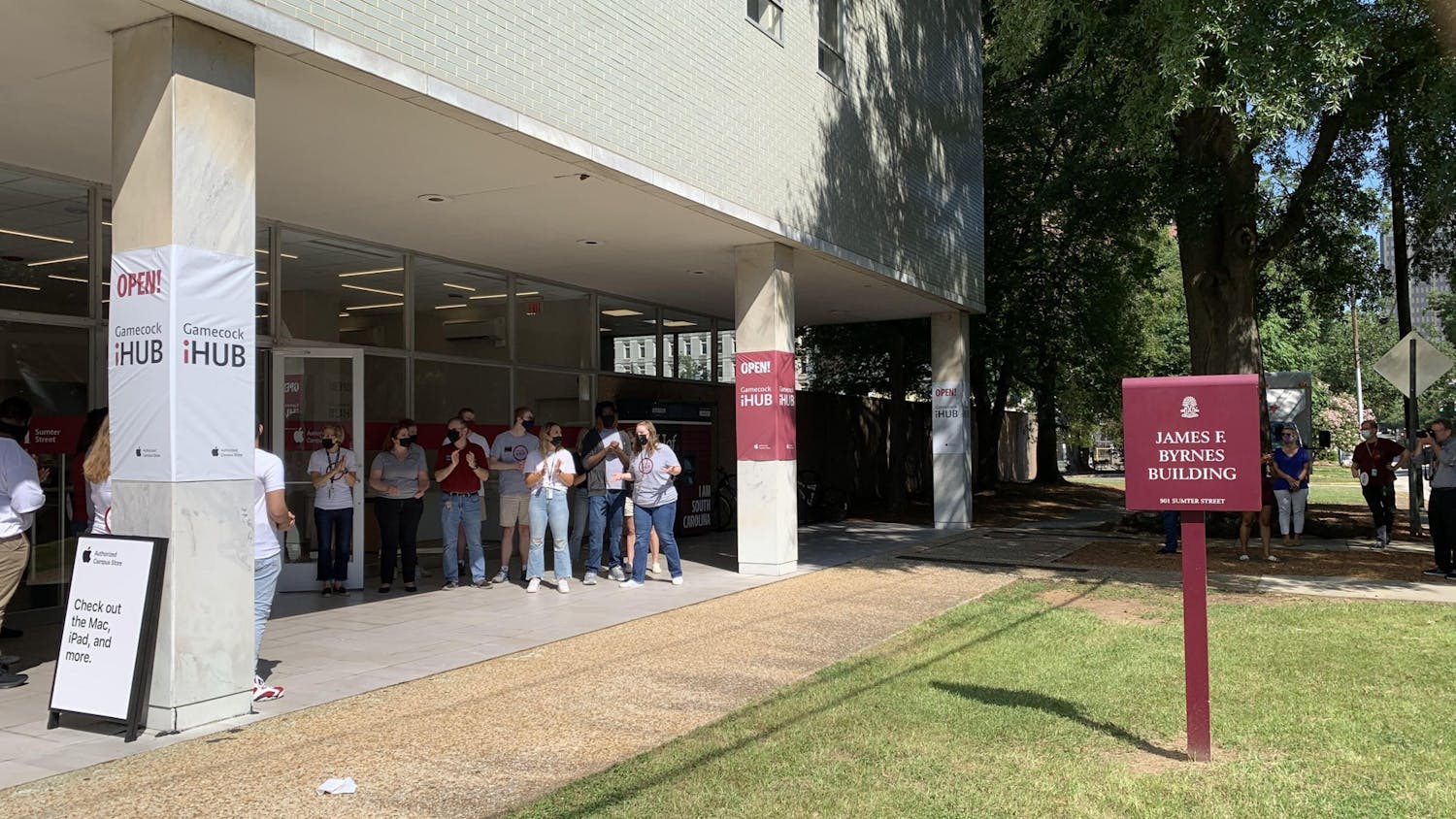 Students working at the new iHub clap as people enter the store. The store opened Aug. 13, 2021, and will service and provide Apple products to the USC community.