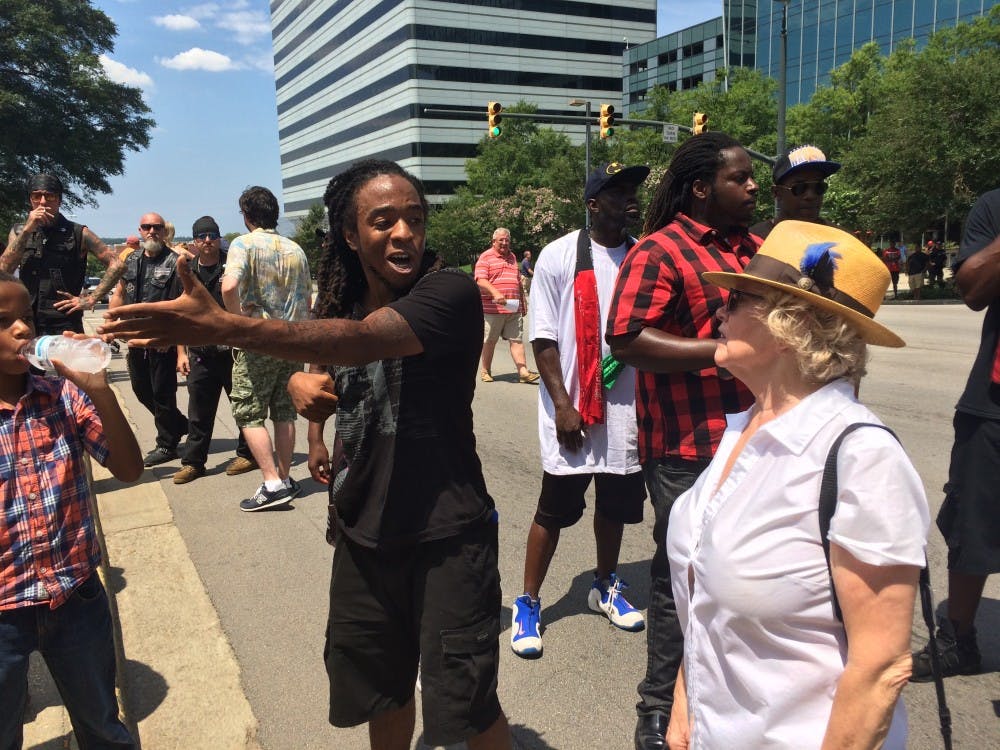 Protesters stand on the Gervais Street side of the SC State House and speak out against a Confederate flag rally.