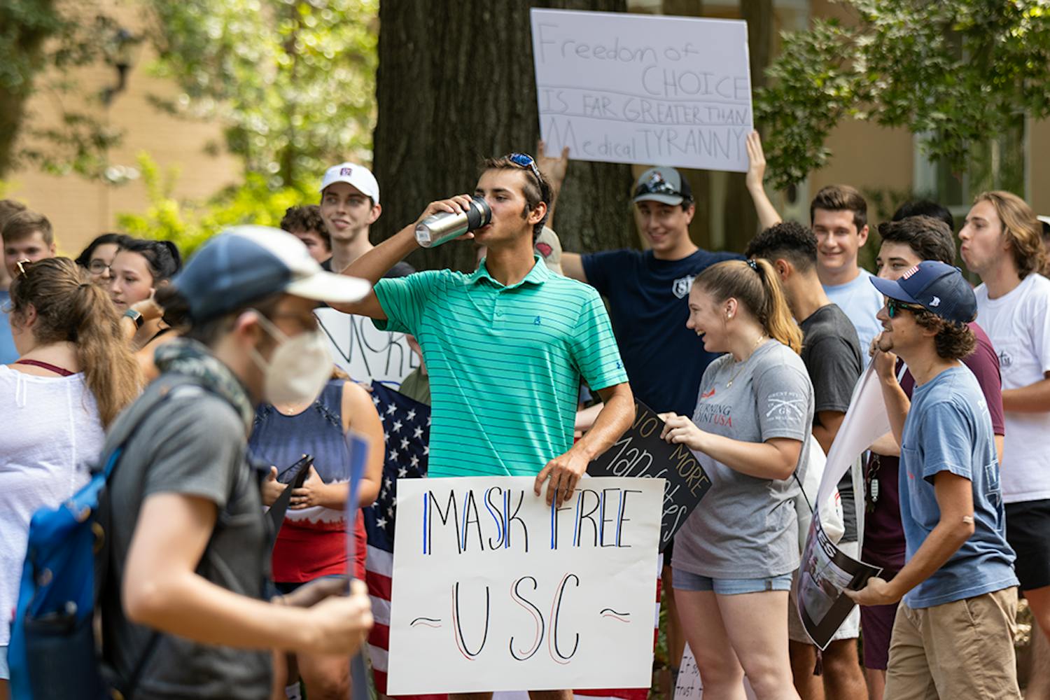 John Hladun (center), student body senator for the Darla Moore School of Business, on the Horseshoe holding a "MASK FREE 鶹С򽴫ý" poster. The protest came after interim president Harris Pastides reinstated the mask mandate on campus.