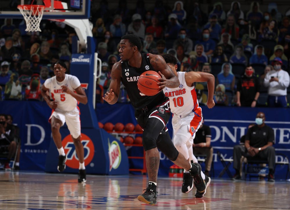 Redshirt sophomore, Jermaine Couisnard, dribbles the ball down the court as a Florida Gators player runs after him. South Carolina won the game 72-66 on Feb. 3, 2021.