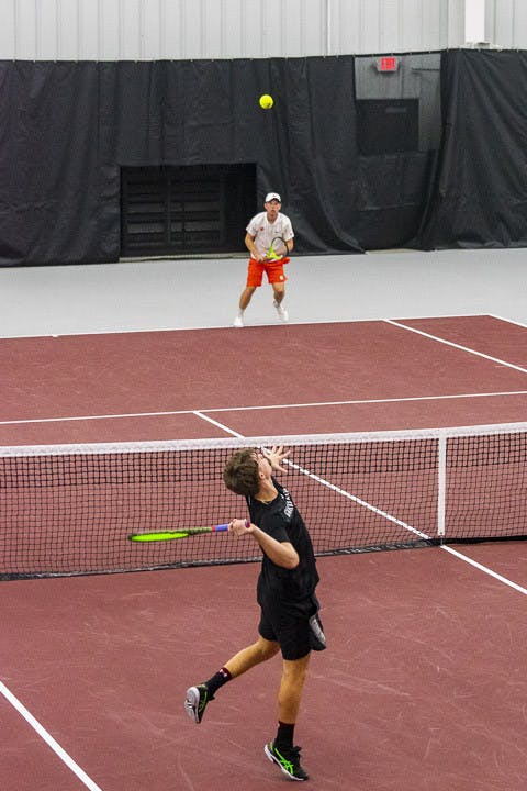 Junior Connor Thomson serves the ball over to his Clemson opponent during a doubles tournament at the Carolina Indoor Tennis Facility on Feb. 3, 2022. The Gamecocks beat the Tigers 7-0, marking the third consecutive year South Carolina has claimed the matchup.