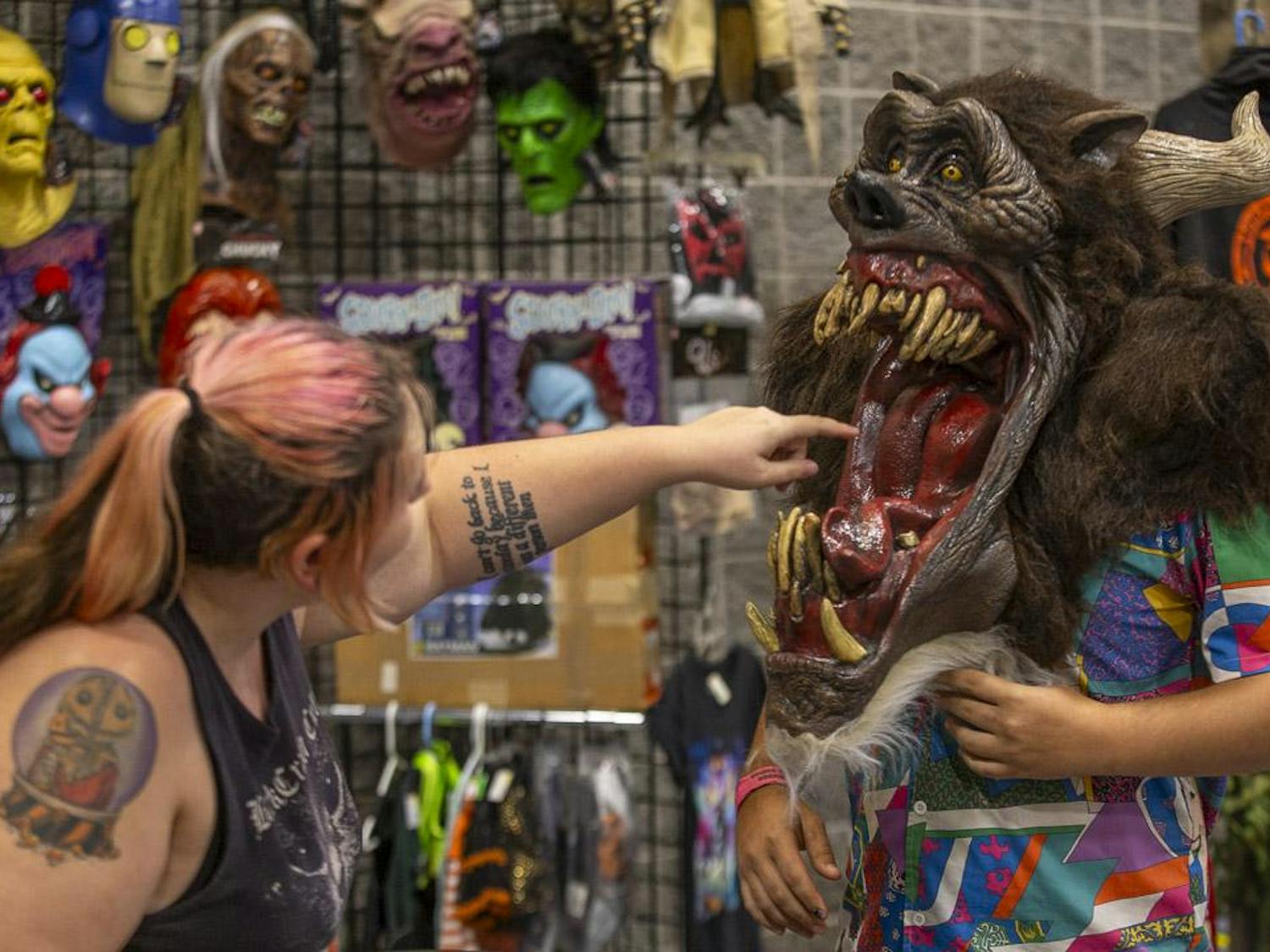 Cassie Wing (left), the owner of Wretched Collections, sticks her finger inside a monster mask worn by Stone McLinde (right) during the South Carolina Horror Convention at the Columbia Metropolitan Convention Center on Sept. 16, 2023. Wretched Collections, based out of Lexington, South Carolina, has a collection of more than 8,500 costumes, alternative fashion and other types of clothing and apparel.