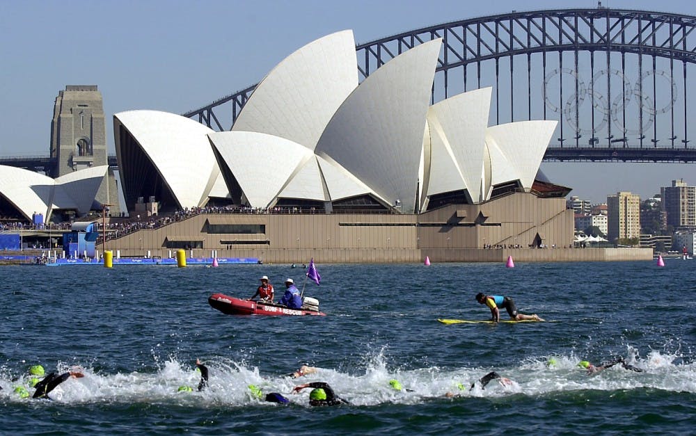 KRT OLYMPICS STORY SLUGGED: TRIATHLON KRT PHOTOGRAPH BY JOE LEDFORD/KANSAS CITY STAR (September 17) SYDNEY, AUSTRALIA-- Swimmers splash through the water of Farm Cove during the first portion of the Men's Triathlon as spectators watch from boats and buildings Sunday September 17, 2000 as the Sydney Opera House is the start and finish lines for the event.  Rescue personnel also followed the swimmers. (KC) PL KD BL 2000 (Horiz) (lde) 