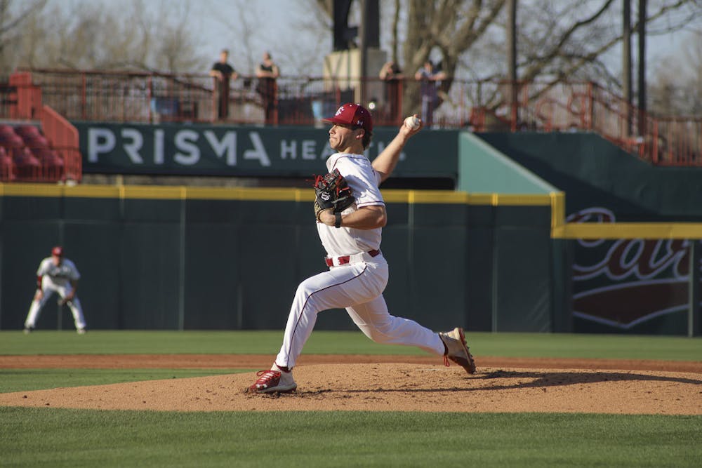 <p>Junior pitcher James Hicks throws a pitch to a Queens batter during the matchup between the Gamecocks and the Royals at Founders Park on Feb. 22, 2023. South Carolina beat Queens 12-0.</p>