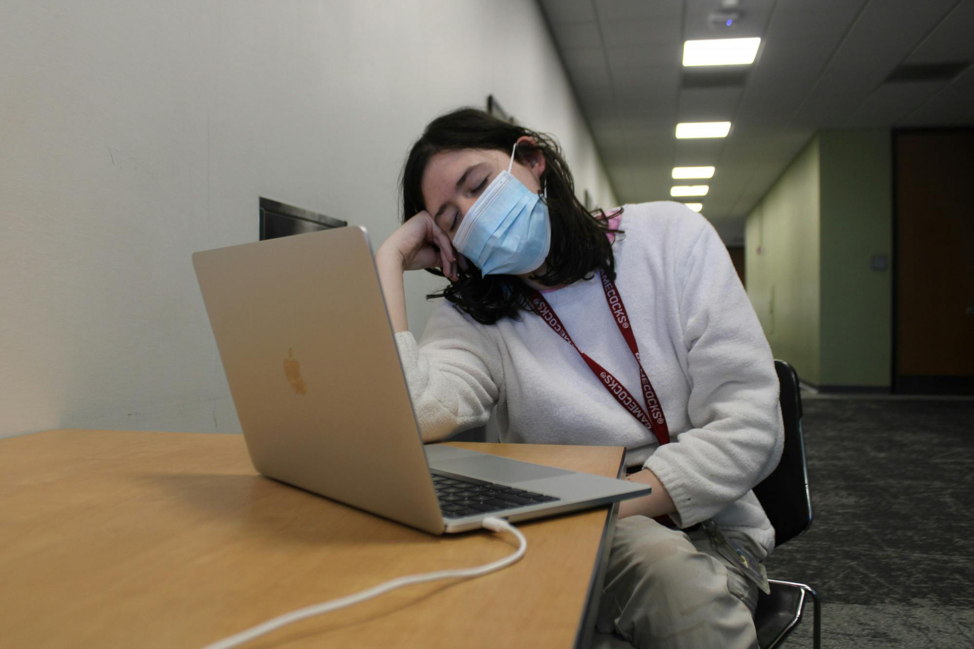 A photo illustration of second-year undecided student Bridget Blackwell fighting to stay awake while working on an assignment in Russell House on Feb. 6, 2023. After two years of online learning, students can struggle with transitioning back to in-person lectures, retaining good study habits and focusing for extended periods of time.