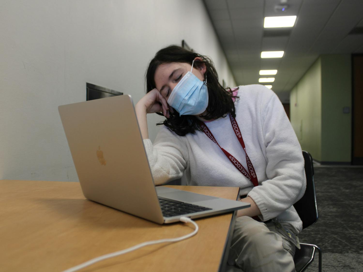 A photo illustration of second-year undecided student Bridget Blackwell fighting to stay awake while working on an assignment in Russell House on Feb. 6, 2023. After two years of online learning, students can struggle with transitioning back to in-person lectures, retaining good study habits and focusing for extended periods of time.