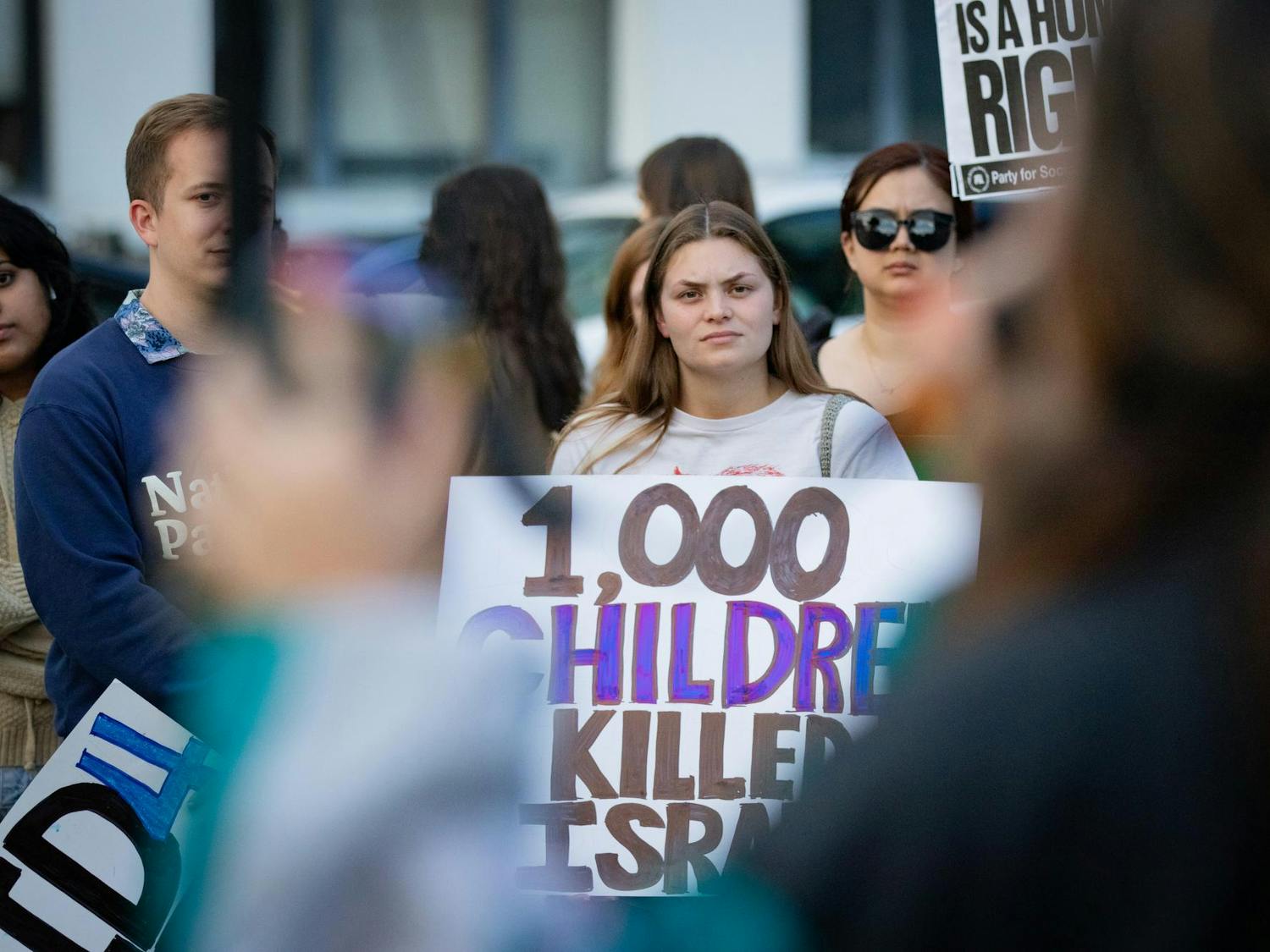 A protestor stands holding a sign that reads "1,000 children killed in Israel" at the Free Palestine Emergency Demonstration. The rally was held by the North and South Carolina Party for Social Liberation on the Statehouse grounds in Columbia, S.C., on Oct. 17, 2023.