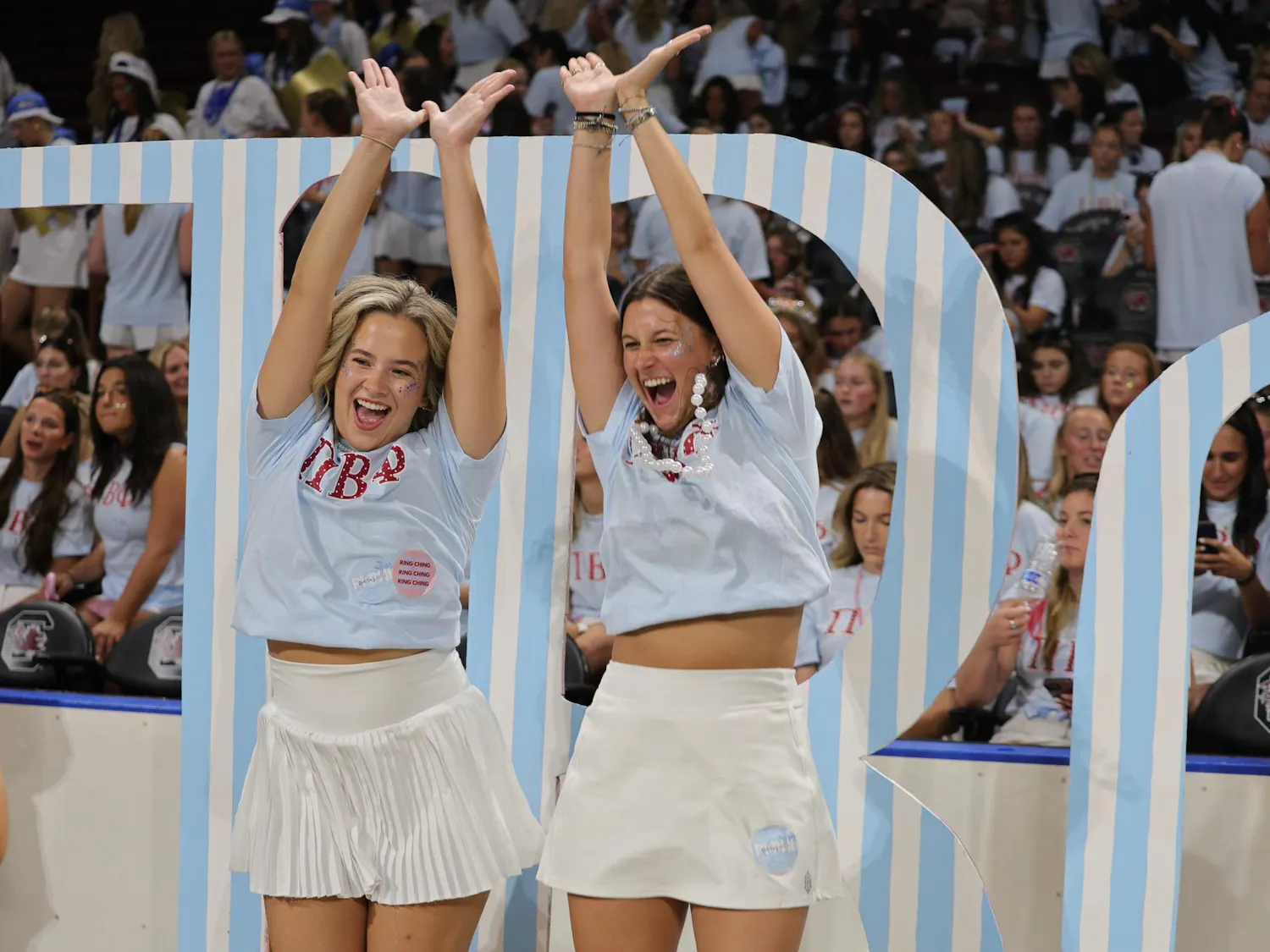 Two members of Pi Beta Phi pose for a photo in front of the sorority’s Greek letters on Aug. 16, 2026, at Colonial Life Arena. Members took photos before the new members entered the arena for Bid Day activities.