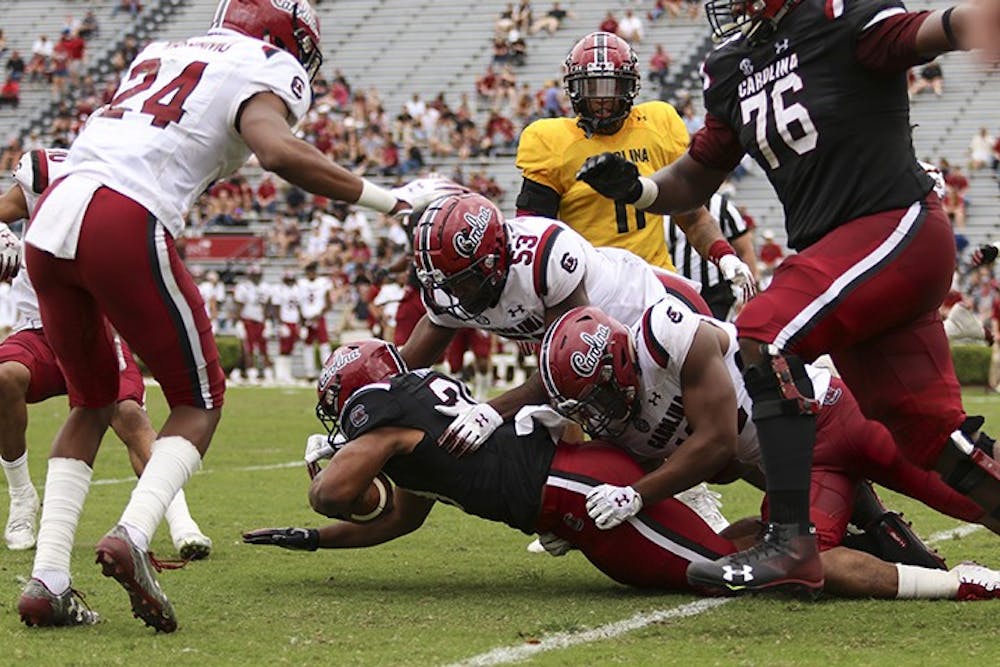 <p>Gamecock players make a tackle during the spring game at Williams-Brice Stadium during the 2019 spring game.&nbsp;</p>