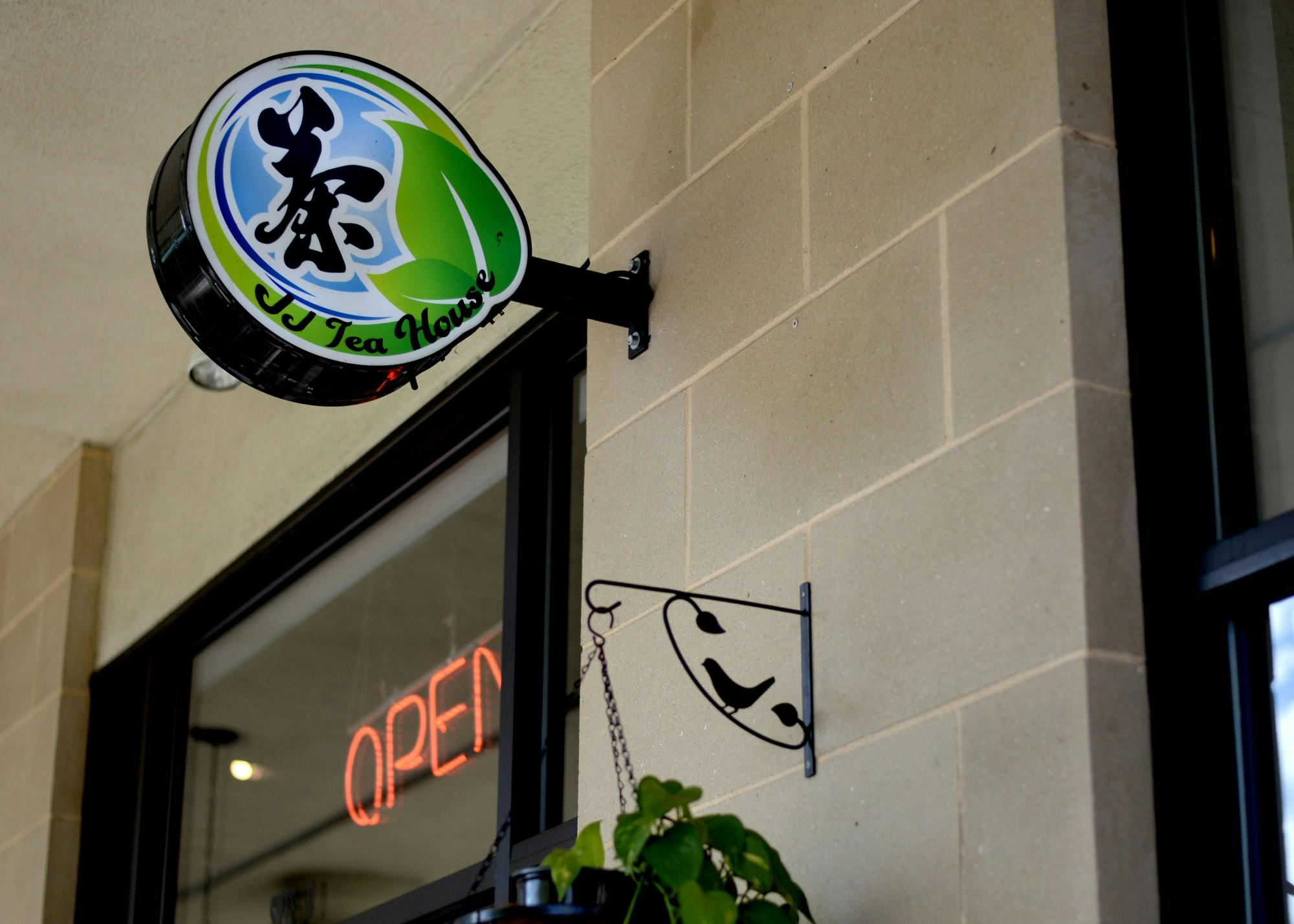 A sign on the front entrance of JJ Tea House welcomes customers.