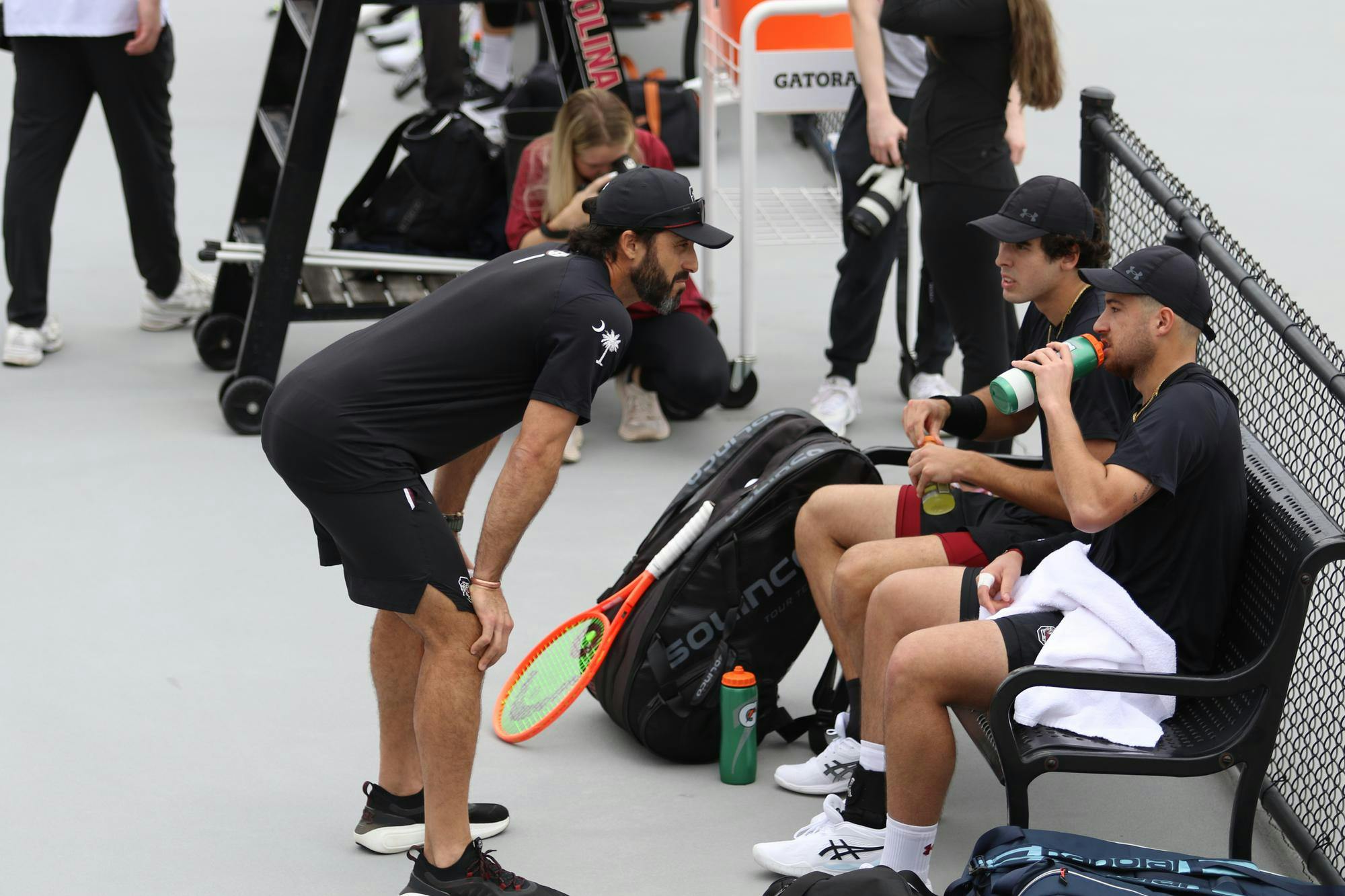 Head coach Josh Goffi talks to redshirt freshman Paul Barbier Gazeu and senior Lucas Andrade da Silva during their doubles match against Texas Feb. 27, 2026. The pair won their match against the Longhorns 6-4.