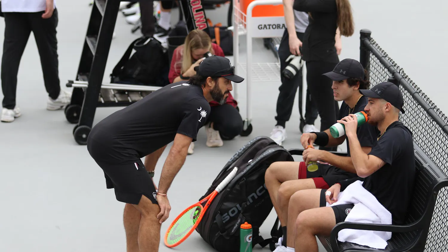 Head coach Josh Goffi talks to redshirt freshman Paul Barbier Gazeu and senior Lucas Andrade da Silva during their doubles match against Texas Feb. 27, 2026. The pair won their match against the Longhorns 6-4.