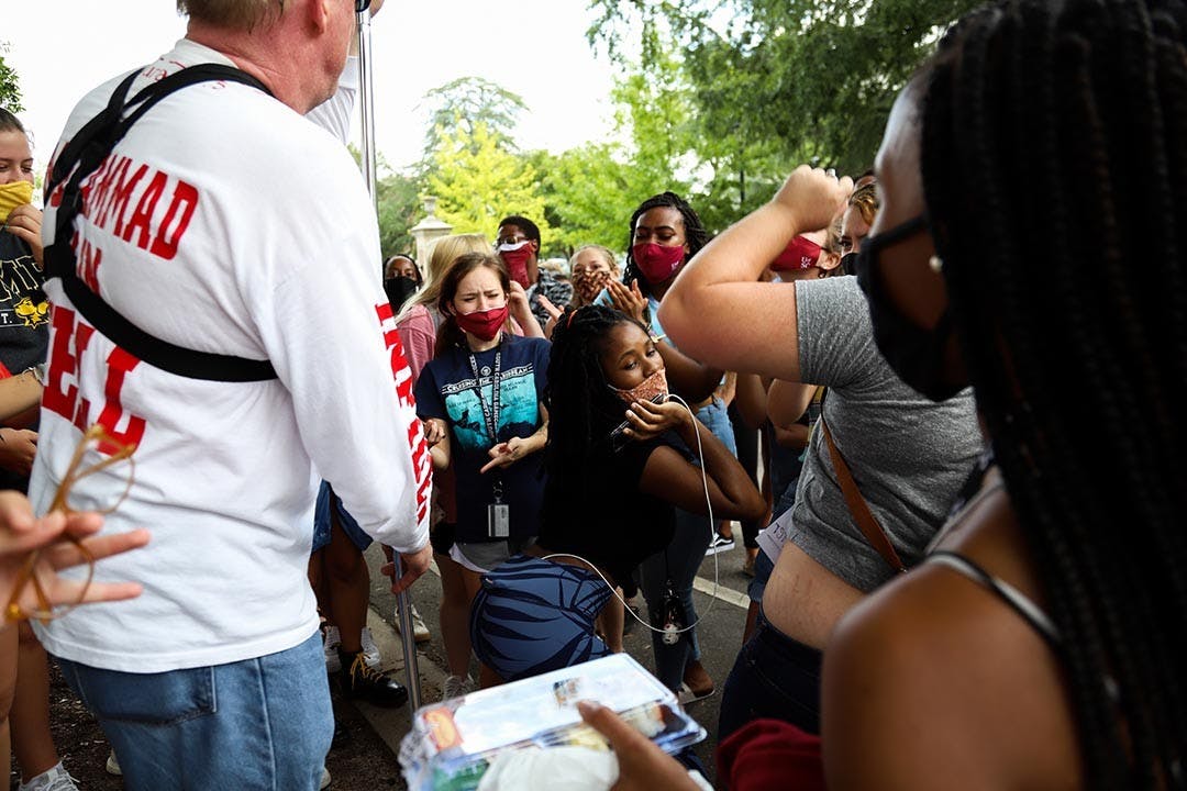 A student dances in front of Jim Gilles while the students surrounding her cheer her on, one even joining her.
