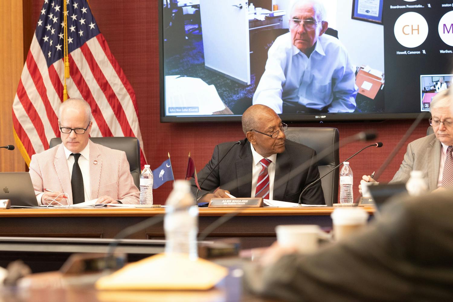 FILE — Secretary Cameron Howell (left) and trustee Alex English (middle) sit alongside 鶹С򽴫ý President Michael Amiridis (right) at a board of trustees meeting on Aug. 18, 2023. The board approved a new research project, a new student advocacy center and a contract extension for head baseball coach Mark Kingston during the meeting.