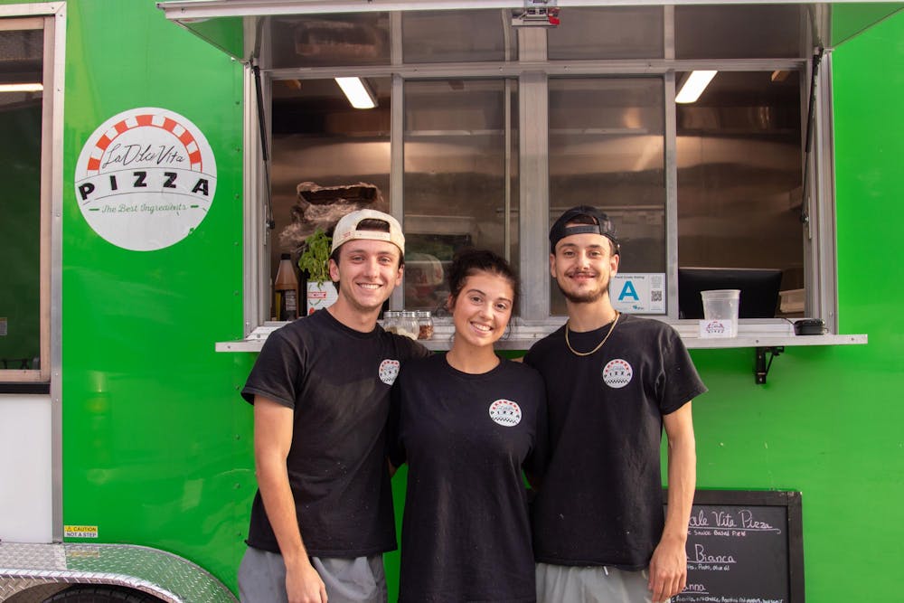 <p>From left, Cook Logan Harris, Cashier Reanna Reed and owner Ben Petty pose for a picture in front of the La Dolce Vita Pizza food truck on Oct. 15, 2024. Petty said his favorite thing about owning the food truck is "serving people and seeing happy faces.”</p>