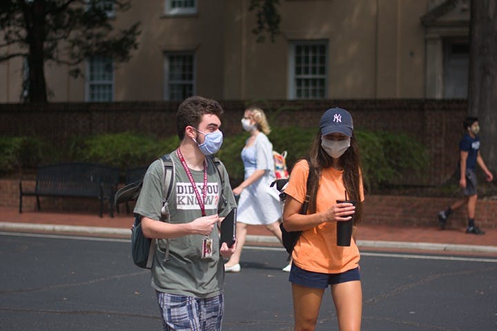Students walk on campus with masks on. The university has documented over 1,000 student violations related to COVID-19 this semester.