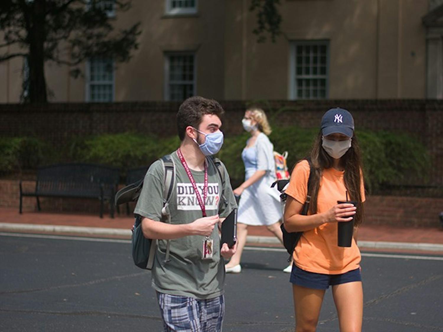 Students walk on campus with masks on. The university has documented over 1,000 student violations related to COVID-19 this semester.