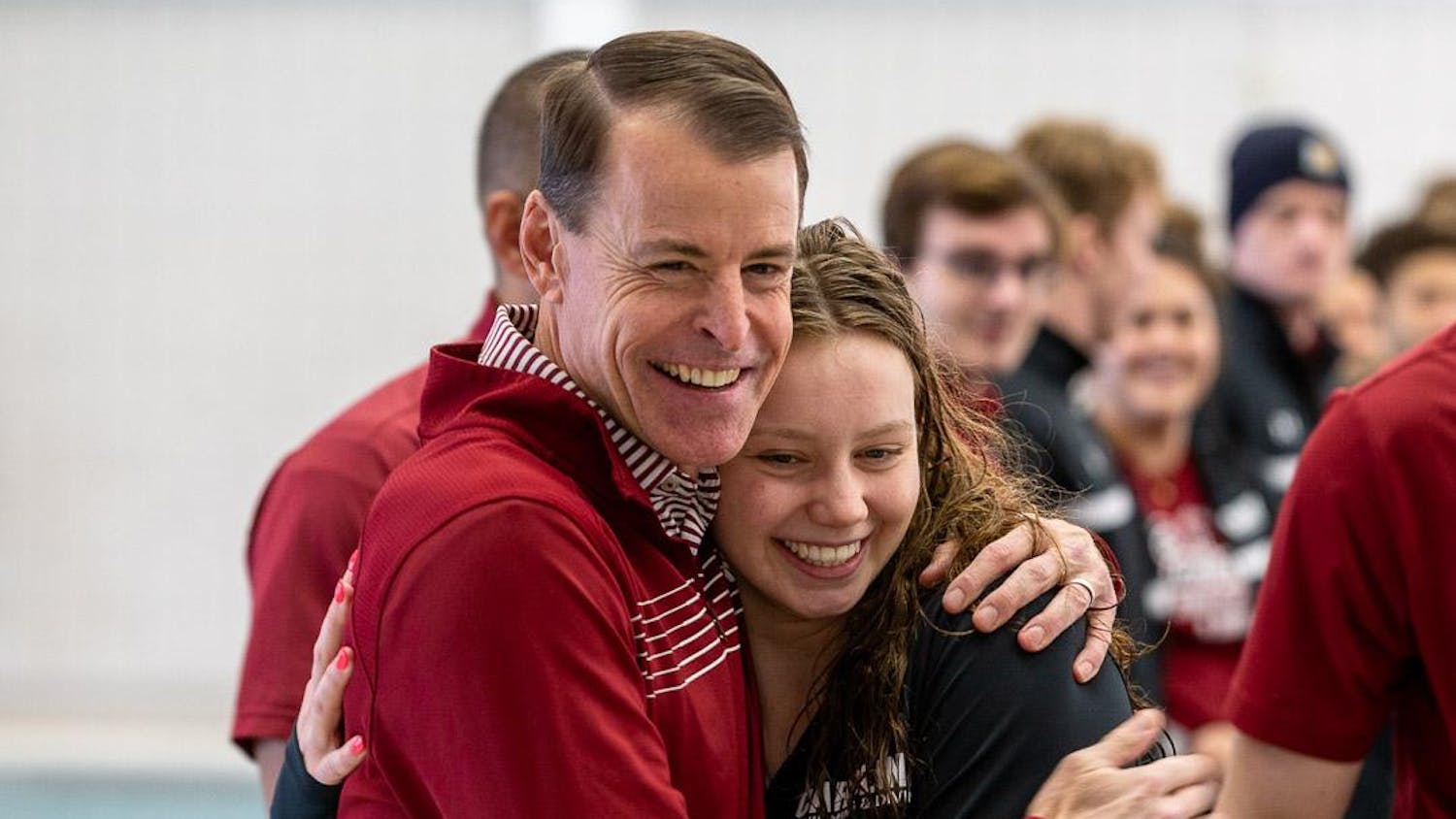 Senior backstroke swimmer Bella Pantano (right) hugs head coach Jeff Poppell during the swim and dive team’s senior recognition event before the tri-meet at the Carolina Natatorium on Jan. 20, 2024. Coaches, staff and family members joined the seniors as they were each presented with plaques.