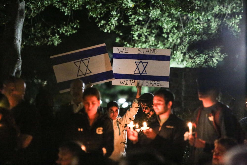 <p>An attendee holds up signs displaying the Israeli flag and a message of support for Israel during a Jewish community vigil in the garden of the Anne Frank Center at the University of South Carolina on Oct. 17, 2023. The vigil was hosted by Gamecocks for Israel, Hillel at UofSC, Alpha Epsilon Pi, Chabad on Campus and the University of South Carolina.</p>