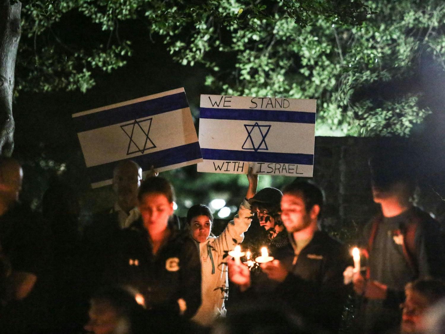 An attendee holds up signs displaying the Israeli flag and a message of support for Israel during a Jewish community vigil in the garden of the Anne Frank Center at the University of South Carolina on Oct. 17, 2023. The vigil was hosted by Gamecocks for Israel, Hillel at UofSC, Alpha Epsilon Pi, Chabad on Campus and the University of South Carolina.