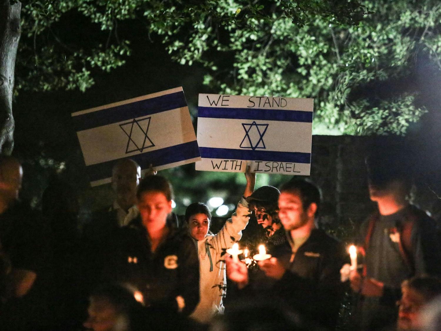 An attendee holds up signs displaying the Israeli flag and a message of support for Israel during a Jewish community vigil in the garden of the Anne Frank Center at the University of South Carolina on Oct. 17, 2023. The vigil was hosted by Gamecocks for Israel, Hillel at UofSC, Alpha Epsilon Pi, Chabad on Campus and the University of South Carolina.
