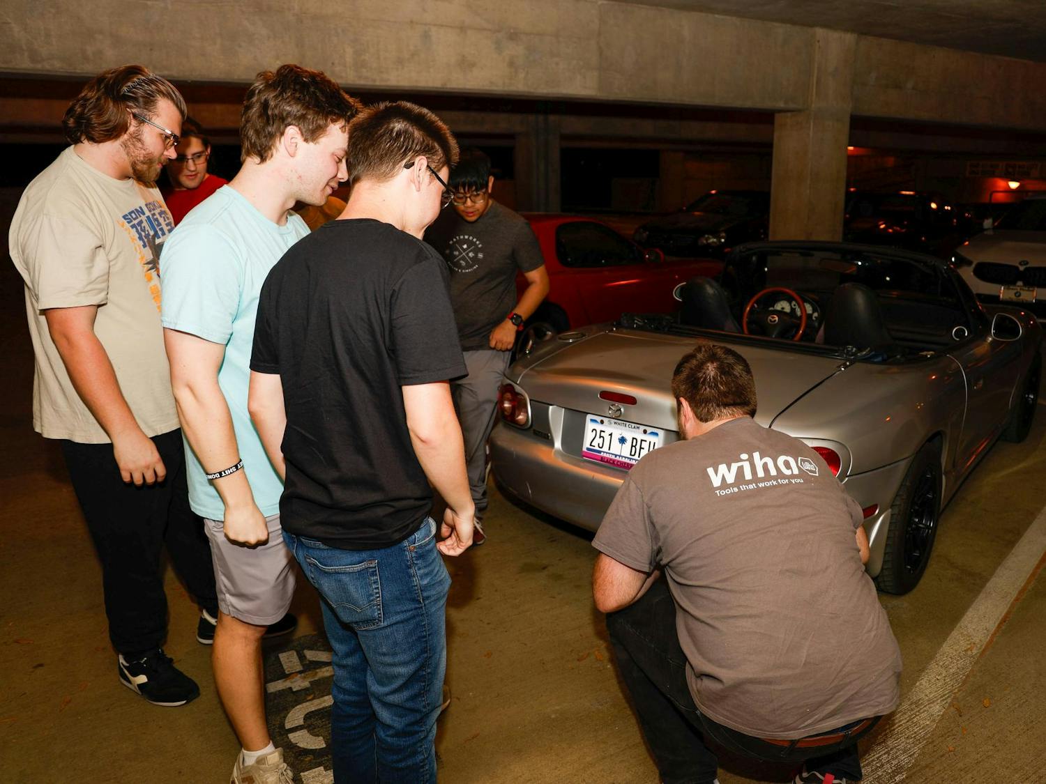 Members of the Carolina Automotive Club examine a club member's new muffler during their weekly meeting at Pendleton Garage on March 25, 2025. All students, regardless of major, are welcome to join and share their love of cars, trucks and motorcycles.