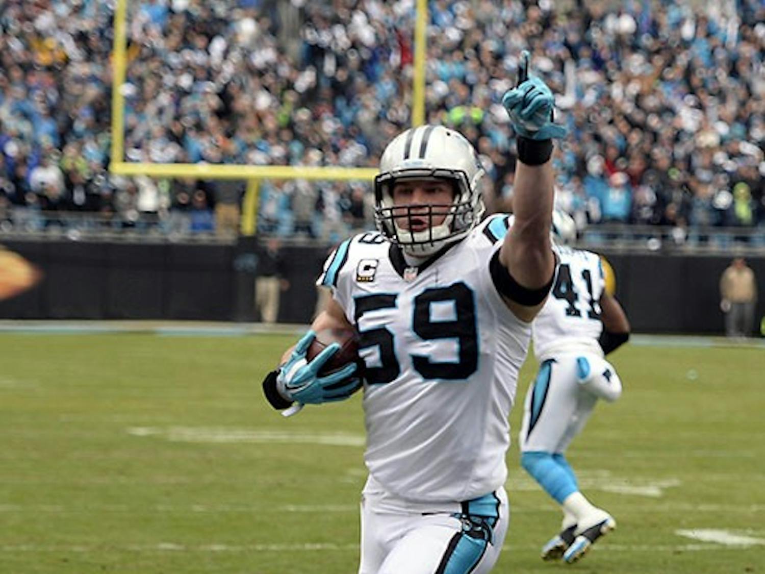 Carolina Panthers' Luke Kuechly (59) celebrates as he returns an interception for a touchdown during the first quarter on Sunday, Jan. 17, 2016, at Bank of America Stadium in Charlotte, N.C. (David T. Foster III/Charlotte Observer/TNS)