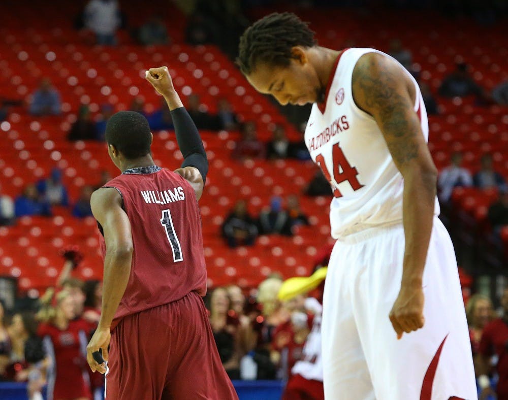 South Carolina's Brenton Williams (1) celebrates as Arkansas' Michael Qualls hangs his head as time expires in the Gamecocks' 71-69 victory in the second round of the SEC Tournament on Thursday, March 13, 2014, at the Georgia Dome in Atlanta. (Curtis Compton/Atlanta Journal-Constitution/MCT)