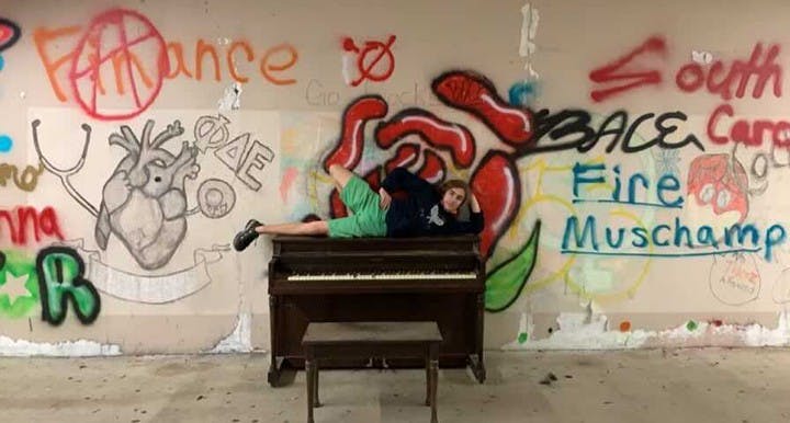 Collin Woods, a first-year computer science student at Clemson, poses on top of the piano. The trio placed it there on Dec. 20.