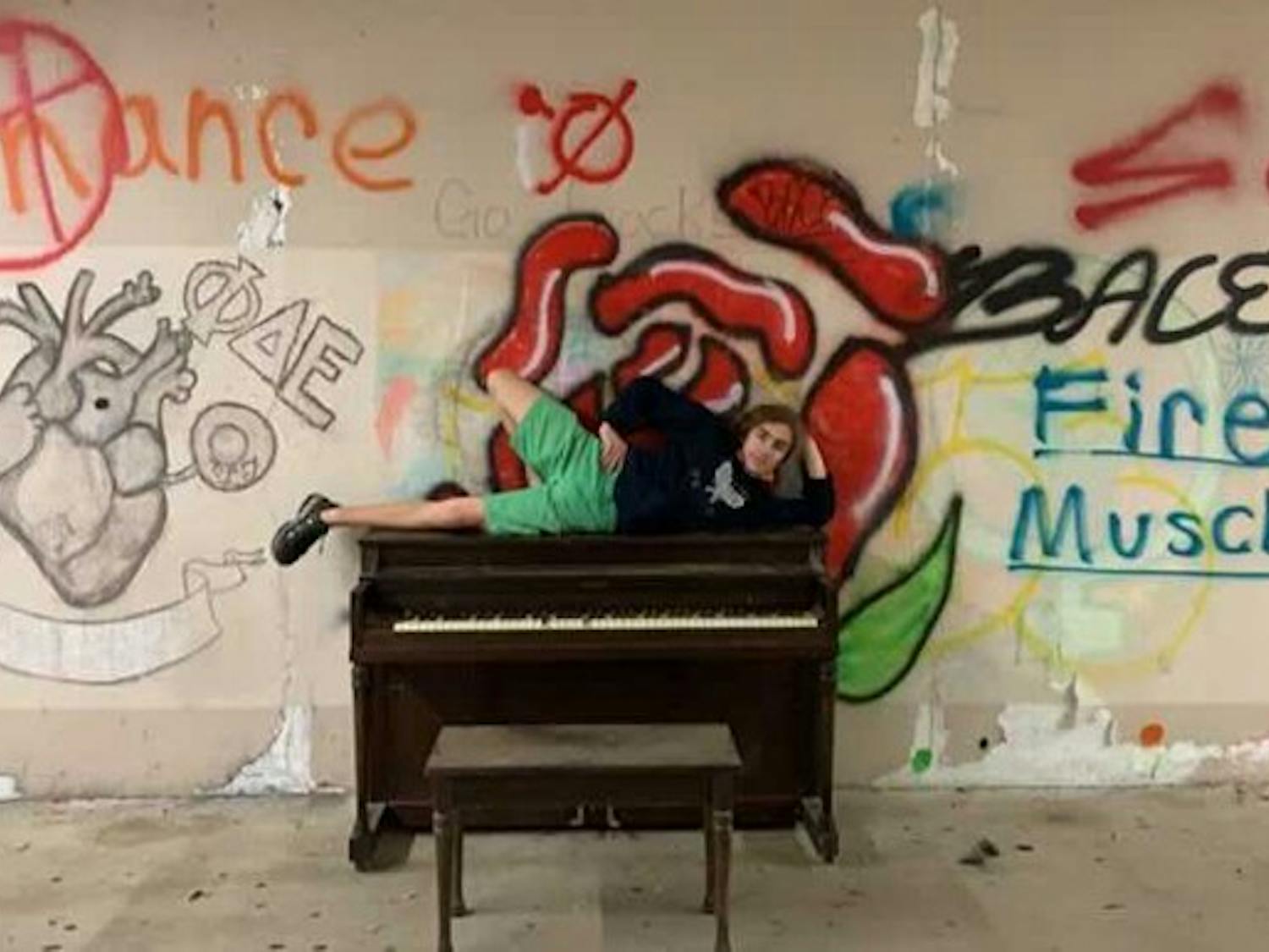 Collin Woods, a first-year computer science student at Clemson, poses on top of the piano. The trio placed it there on Dec. 20.