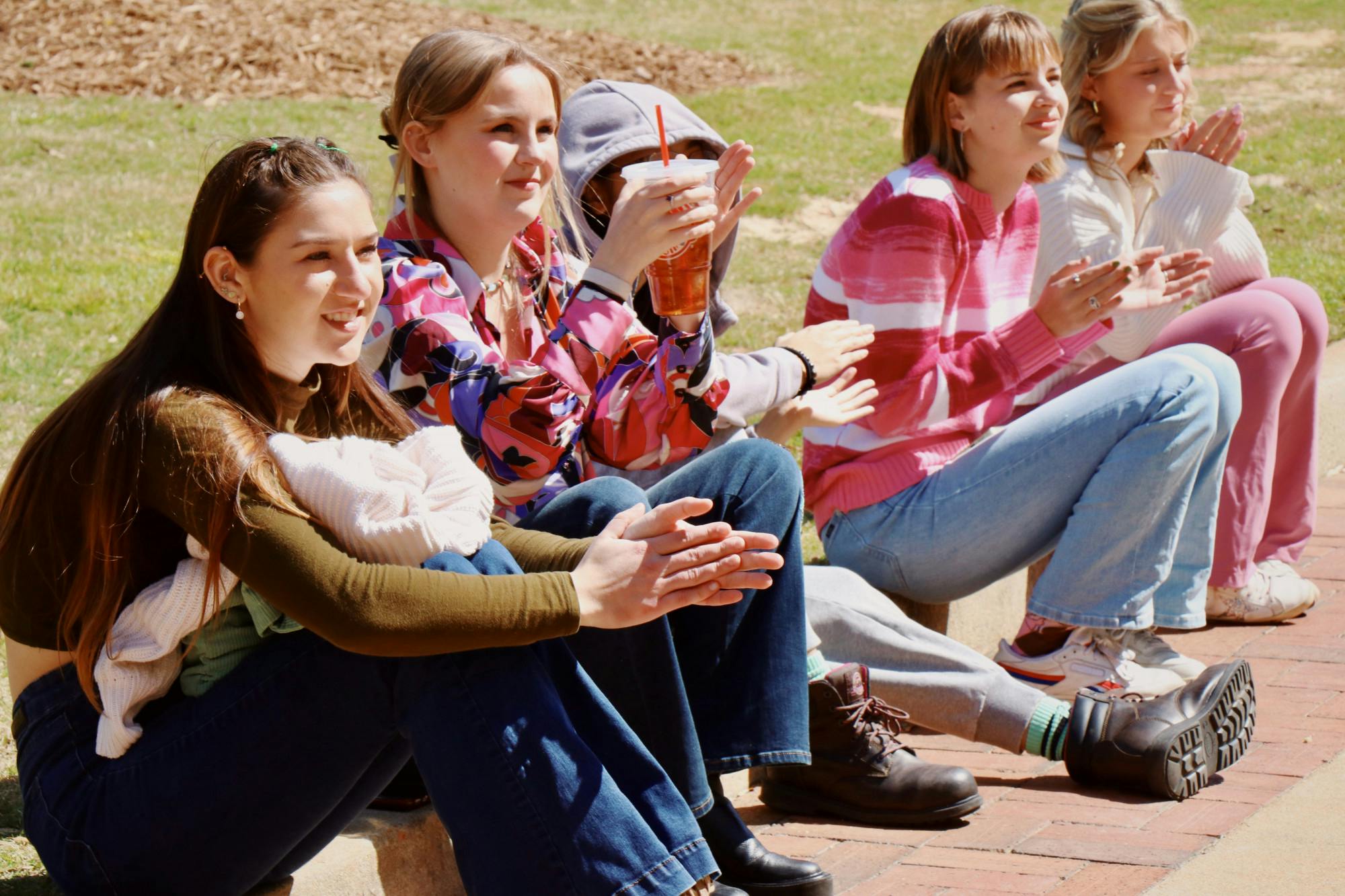 A group of friends enjoy the Women on the Dock performance from the sidewalk on March 20, 2023. The event was a special version of Rock the Dock featuring female musicians.&nbsp;