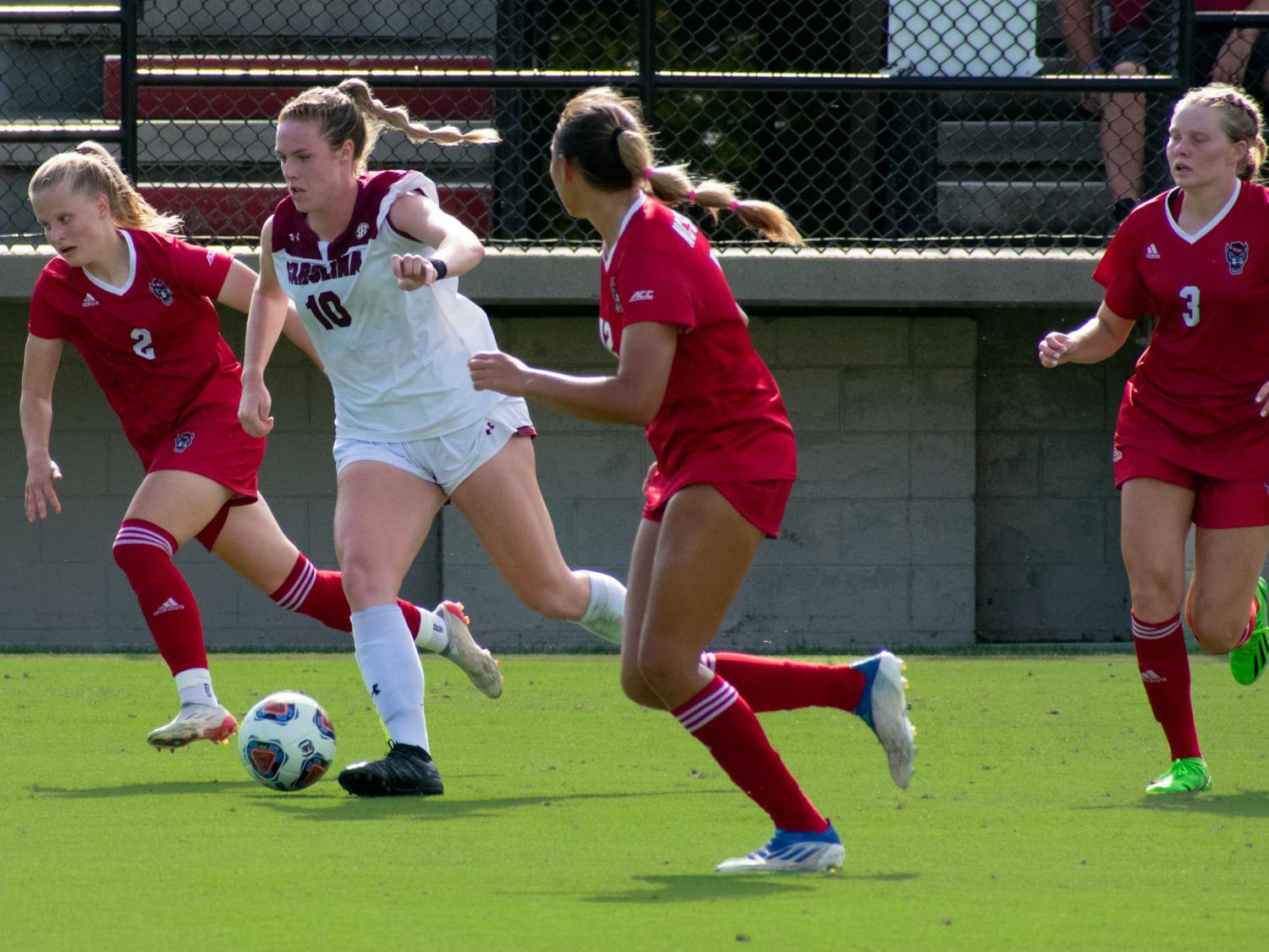 FILE—Junior forward, Catherine Barry, runs the ball past NC State soccer players. The Gamecocks tied with the Wolfpack, 0-0, on Sept. 11, 2022. &nbsp;