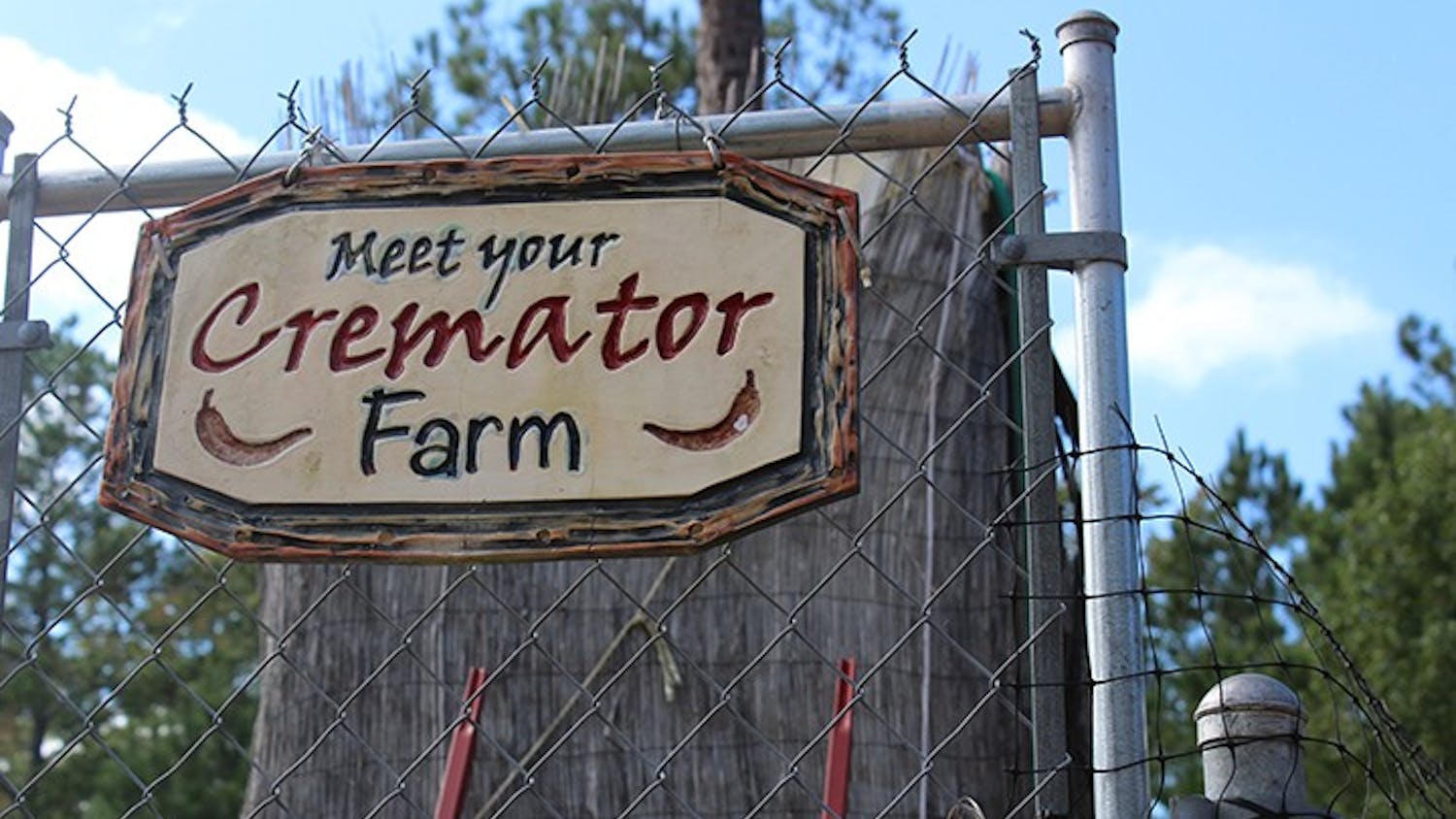 The sign for Meet Your Cremator Farm sits on the front gate. The farm grows peppers that are used to make some of its award-winning hot sauces.