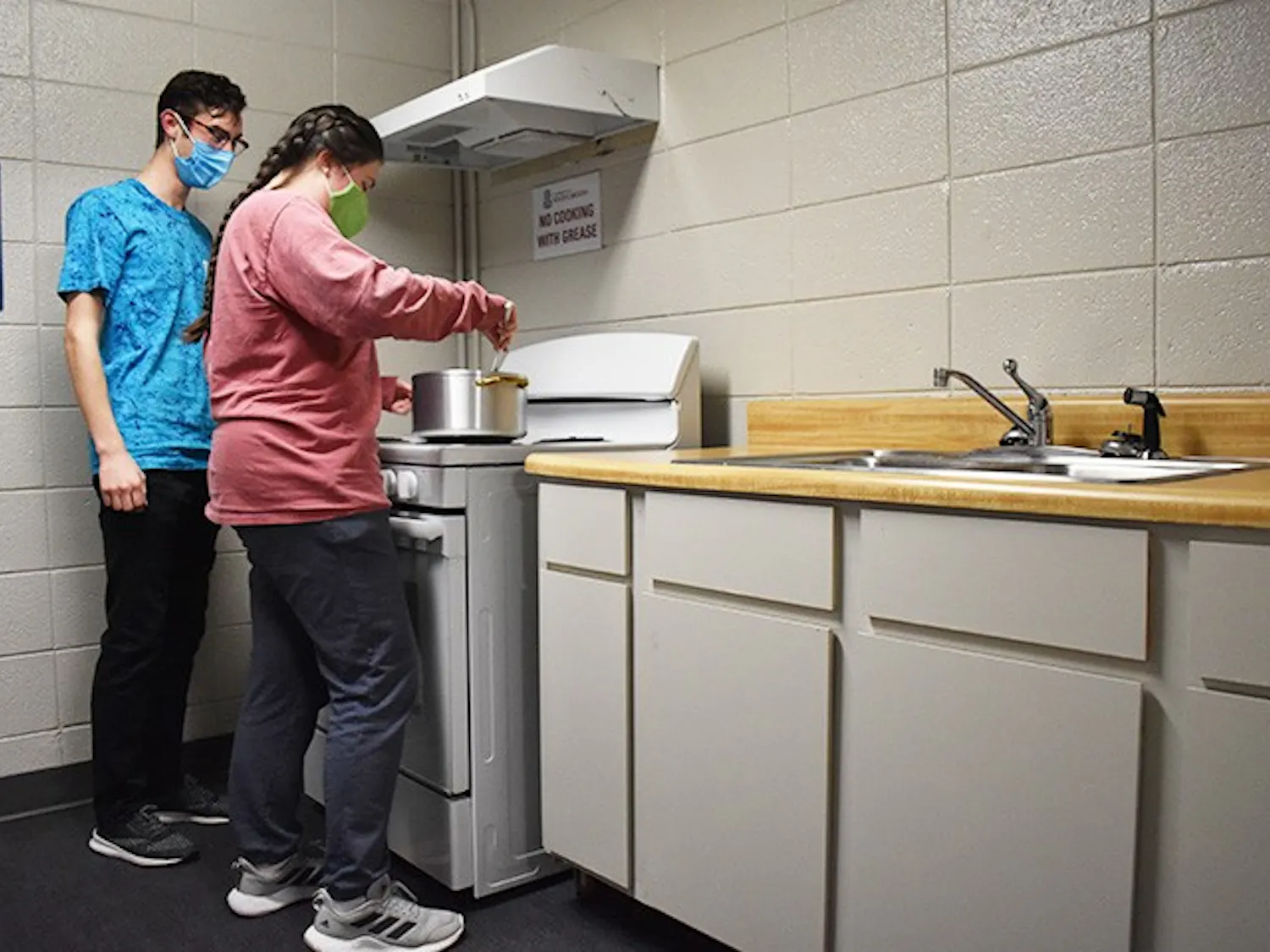 Capstone resident mentor Cecelia Tatro, third-year marketing and management student, and Nic Piazza, first-year civil engineering student, cook in a kitchen in Capstone. Capstone has four floors with kitchens spread throughout the building for residents to use.